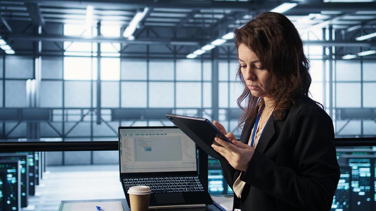 Engineer reviewing figures on a tablet in a data center