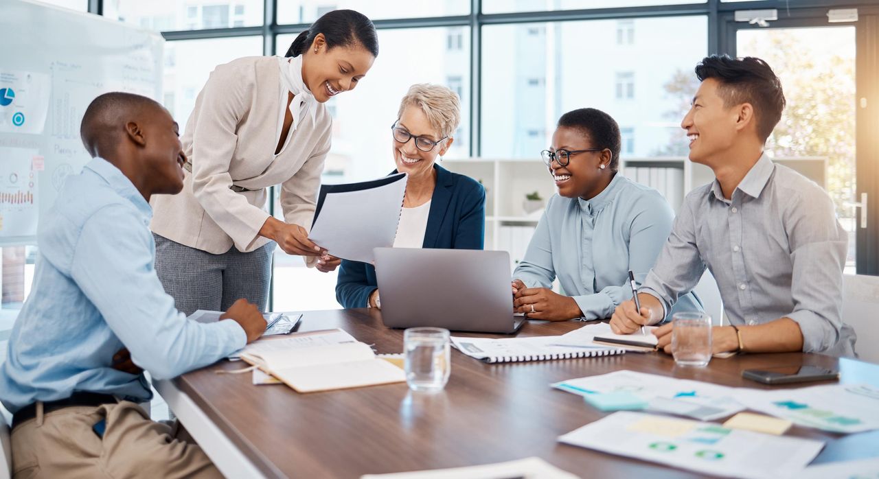 Team reviewing a plan around a conference table