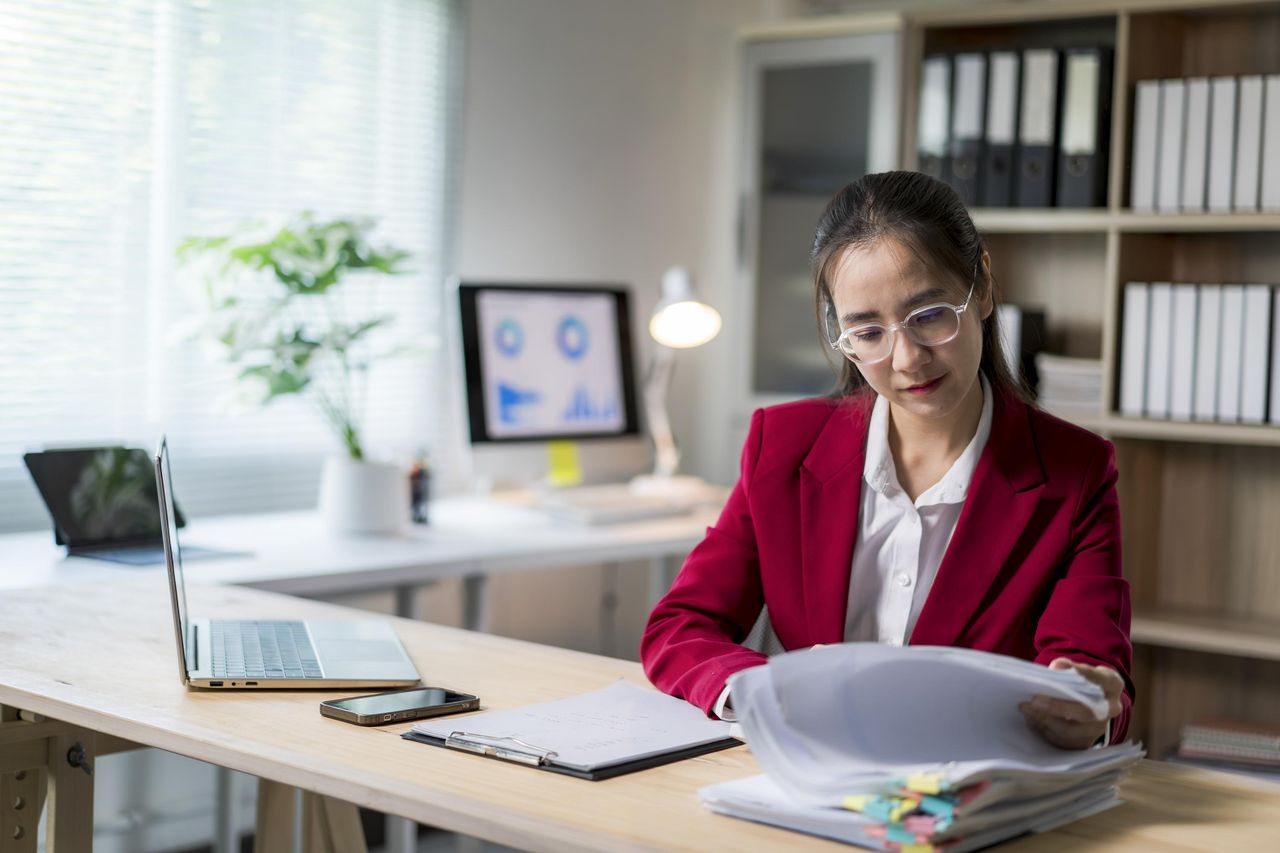 Professional reviewing binders at her desk